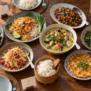 โต๊ะอาหารไทยแบบแบ่งจาน มีข้าว น้ำ และช้อนกลางสำหรับวางแผนมื้อกลุ่ม