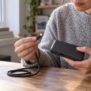 ผู้ถือพาวเวอร์แบงก์และสาย USB-C ที่ยังไม่เสียบเข้ากันบนโต๊ะ